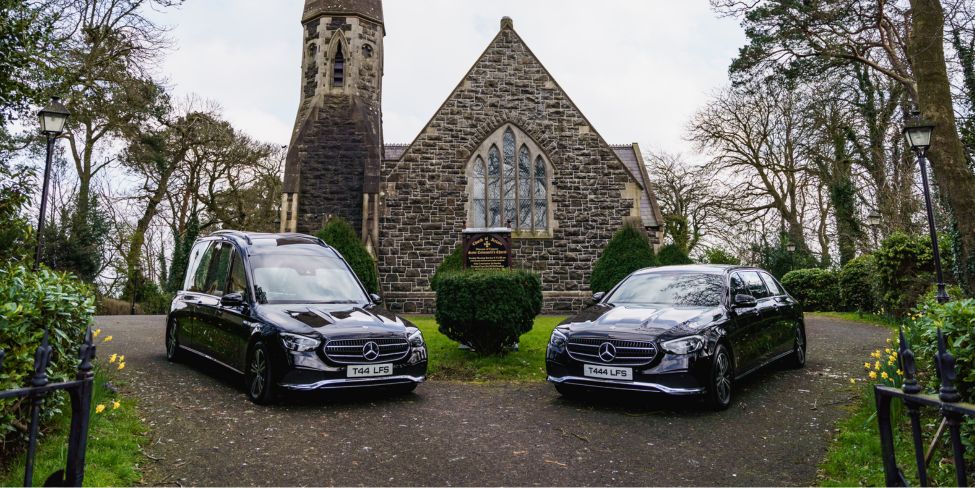 Logans funeral service cars in front of church